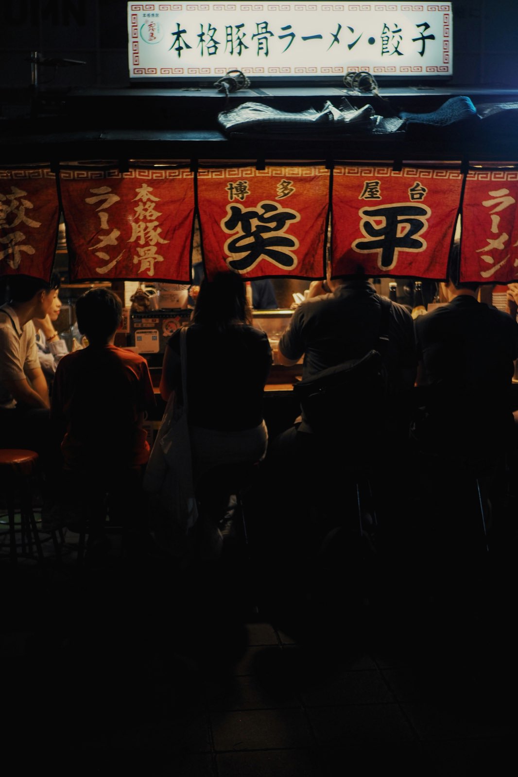 Guests in silhouette at a Hakata yatai ramen stall, Fukuoka