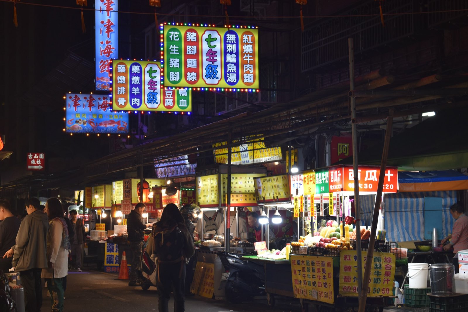 Taipei night market alley under neon signs